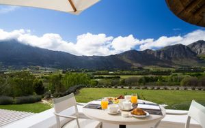 Aerial view of Mont Rochelle hotel and vineyards in the Franschhoek valley with mountain backdrop