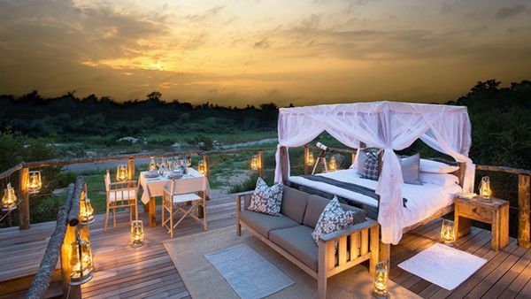 Couple watching sunset over the South African bushveld from a luxury safari lodge deck