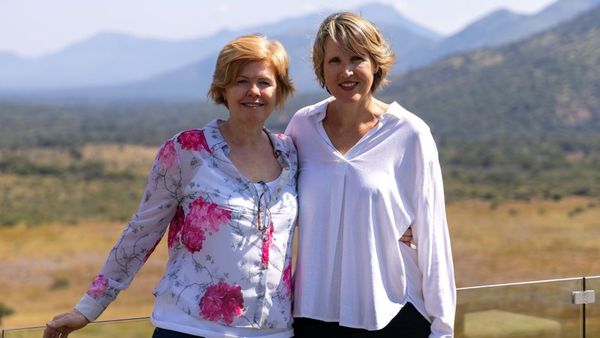 Vikki Jackson and Sian Loehrer, the two founders of Marula Hill, standing together on a deck above open bush