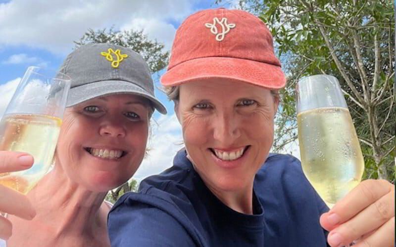 Sian Loehrer and Vikki Jackson of Marula Hill Travel smiling and toasting with champagne—celebrating the joy, partnership, and personal touch behind every tailor-made African safari they create.