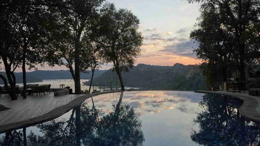 Infinity pool reflecting a mauve sunset over the Matusadona escarpment, Zimbabwe