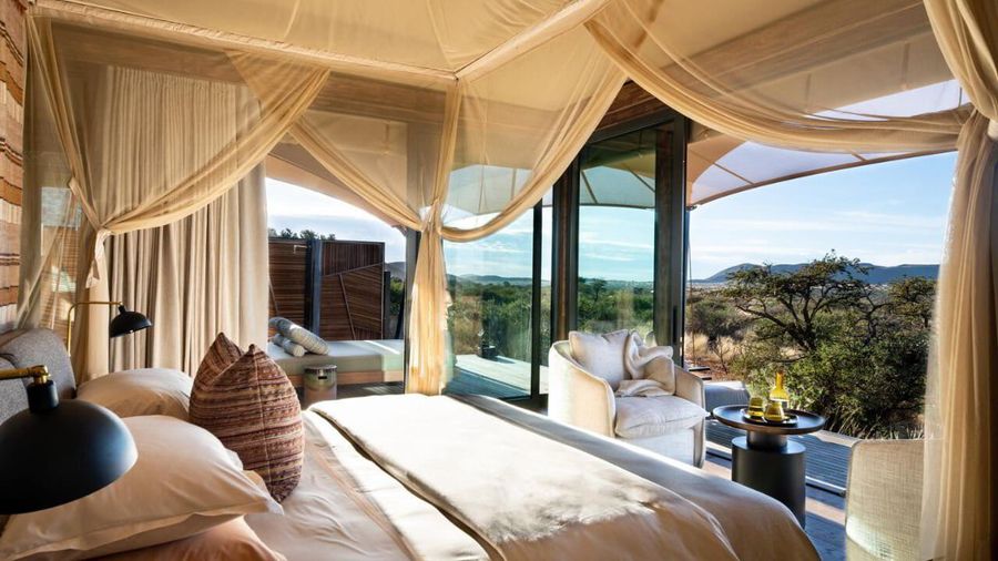 A tented suite at a private game reserve in South Africa, sliding doors open to the bush