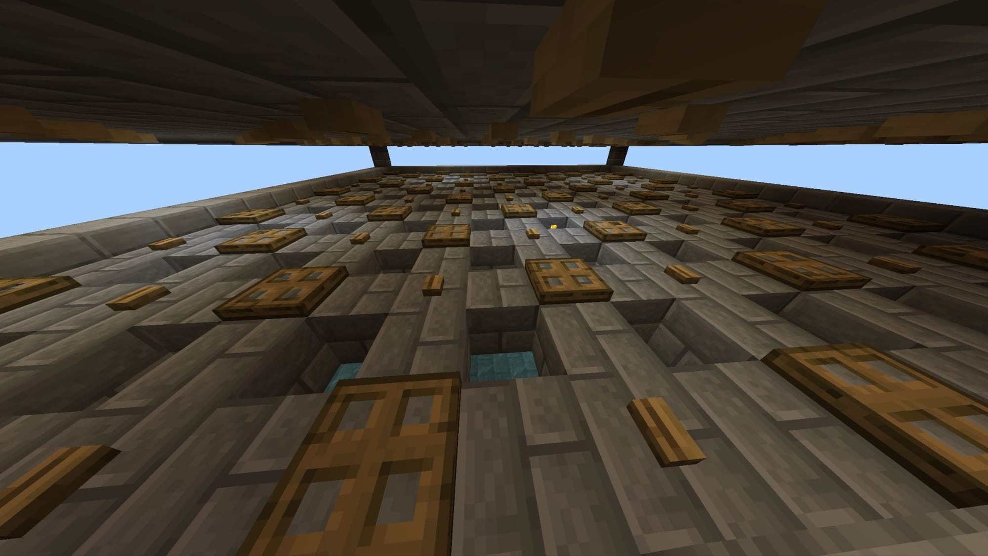 A Minecraft screenshot of a stone floor full of holes, trap doors, and buttons.