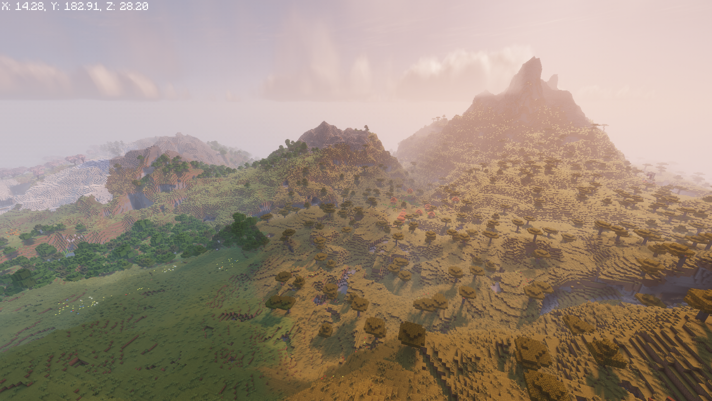 Savanna hills bordering jagged rocky peaks, with a savanna village visible in the distance.