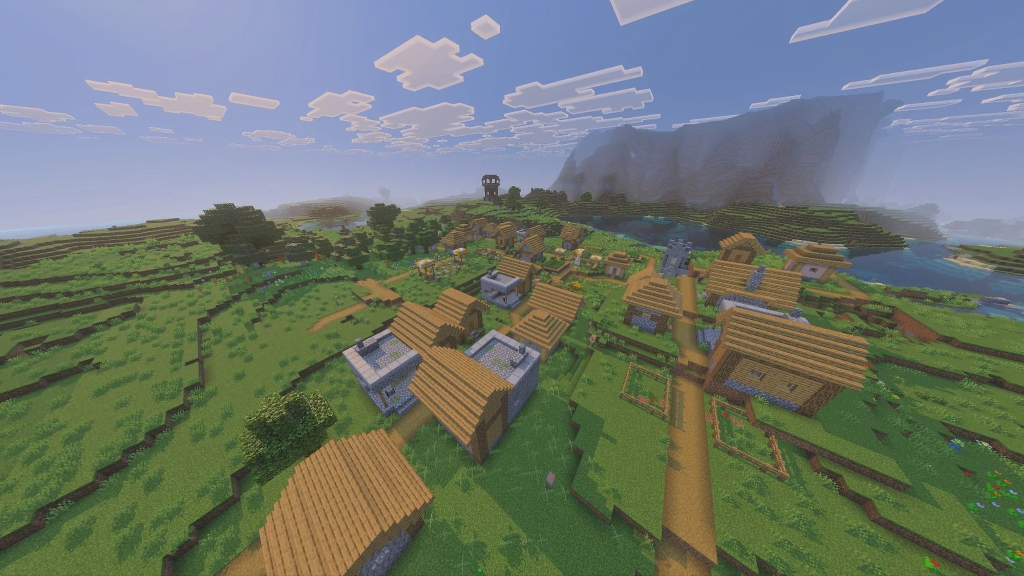 A Minecraft screenshot of as village with an pillager outpost nearby.