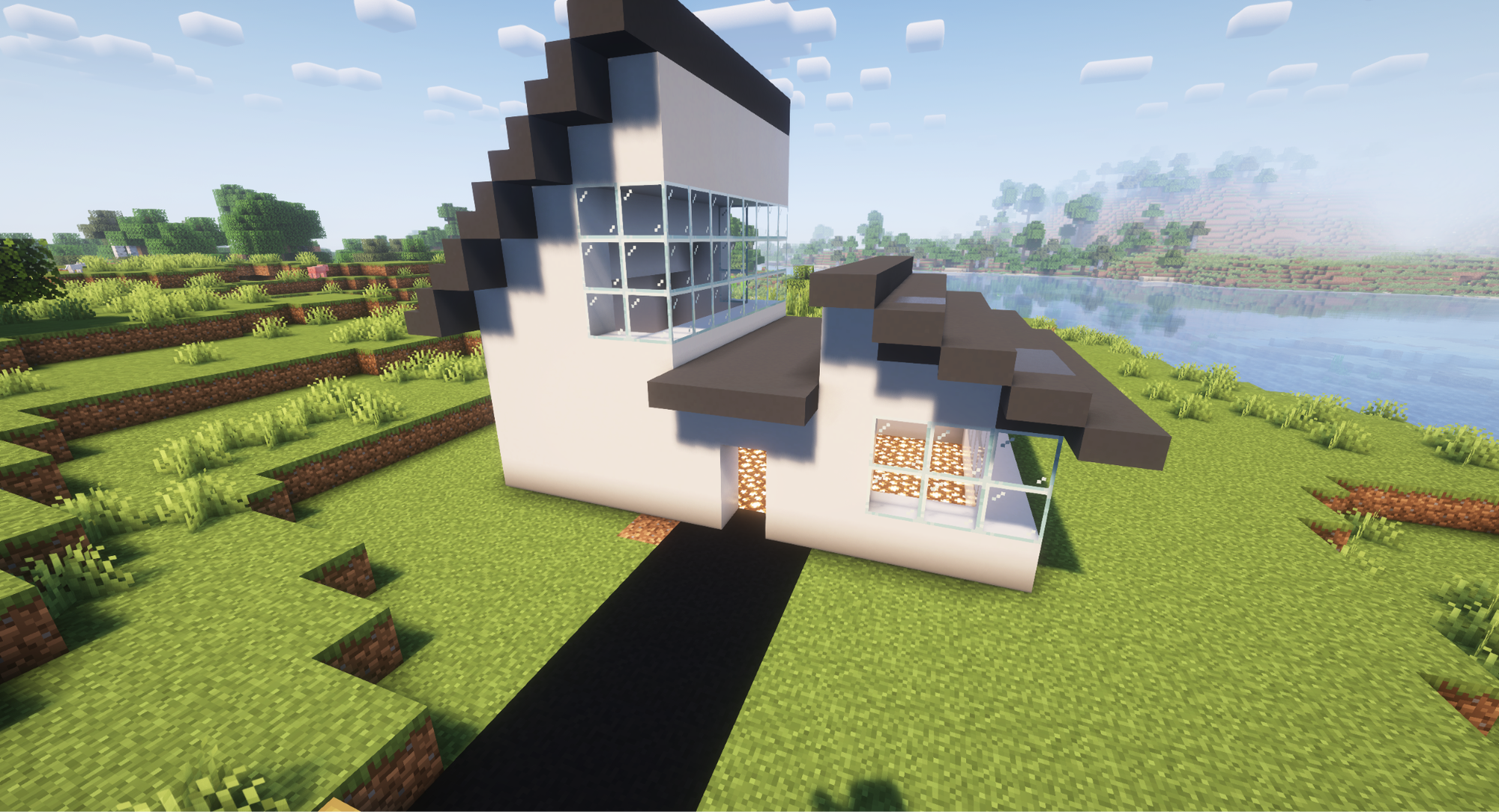 A Minecraft screenshot of a postmodern house with white walls and black roofs.