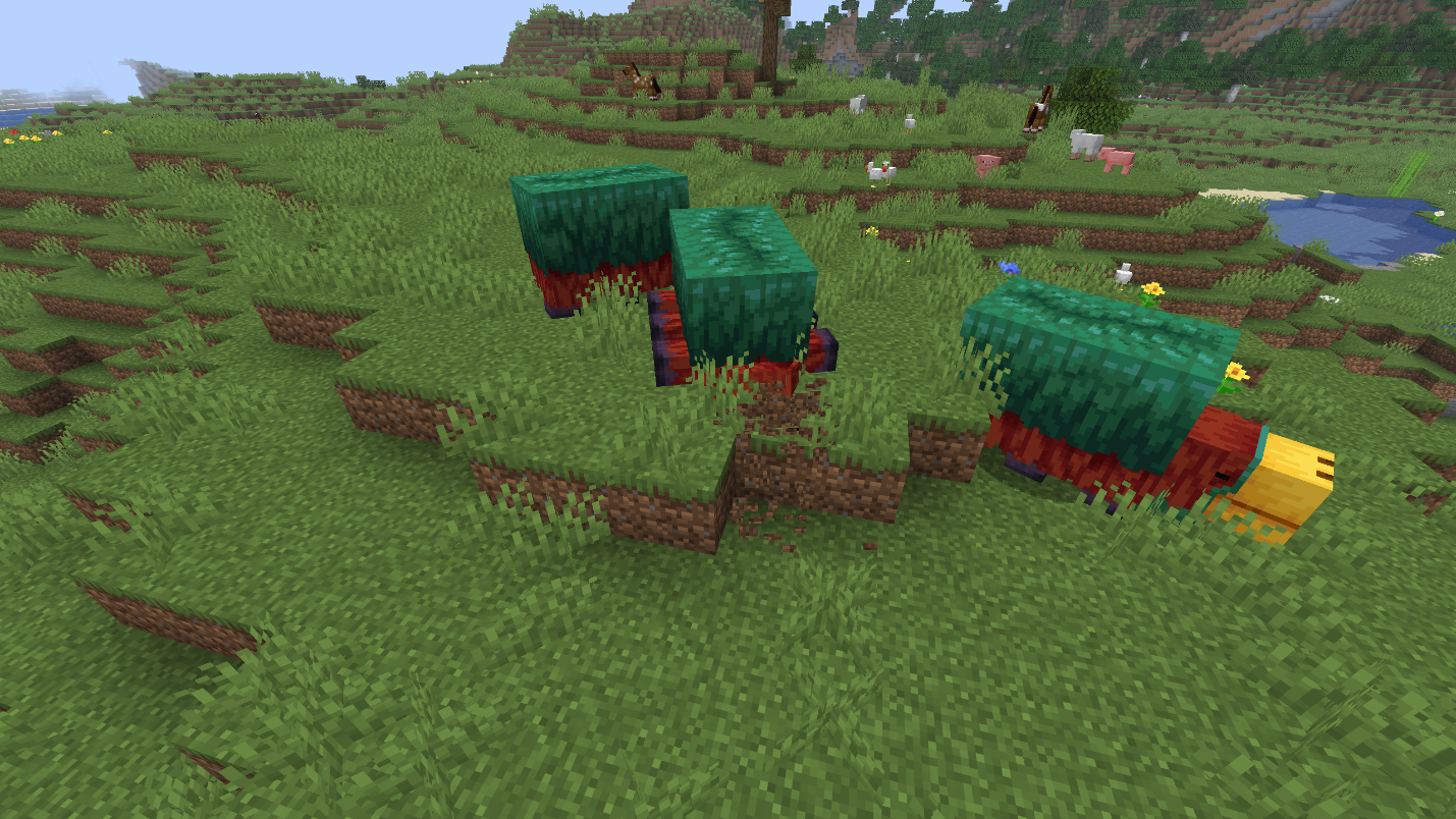 Several sniffers standing in a grassy field with patches of dirt in the grass around them where they have been digging, farm animals grazing nearby
