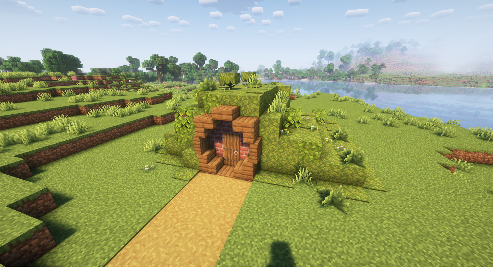 A Minecraft screenshot of a hobbit hole style house covered in greenery.