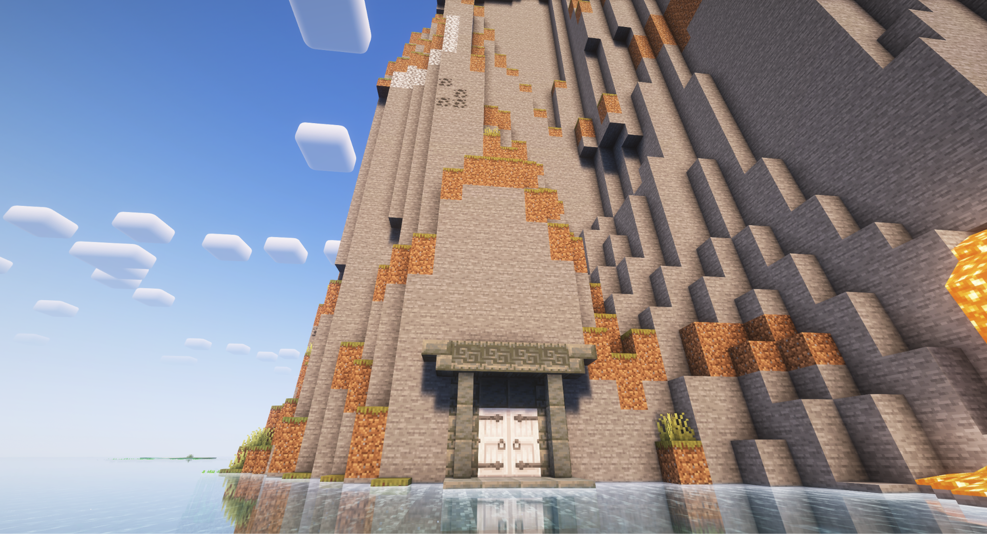 A Minecraft screenshot of a mountainside with a double door entrance.