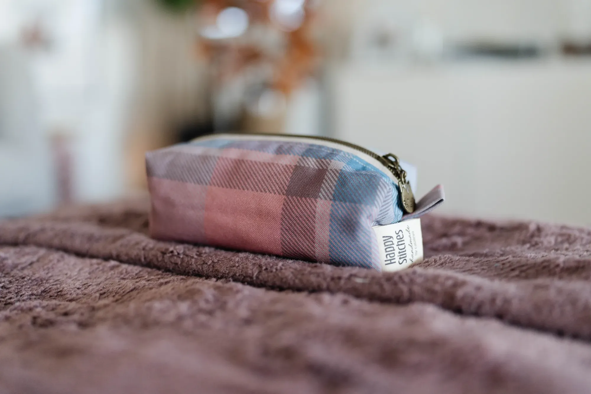 a happy stitches pink stitched bag on a blanket