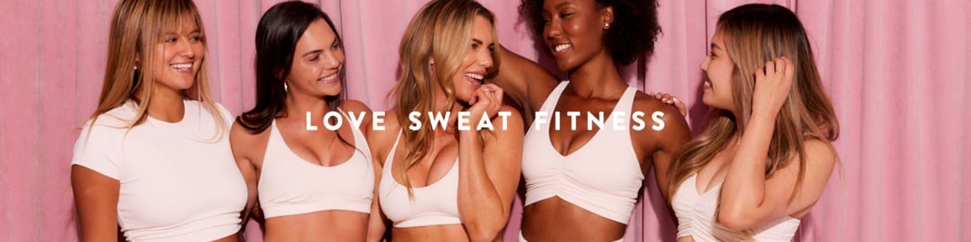 Women in comfortable leisure clothing in the background of a "Love Sweat Fitness" banner