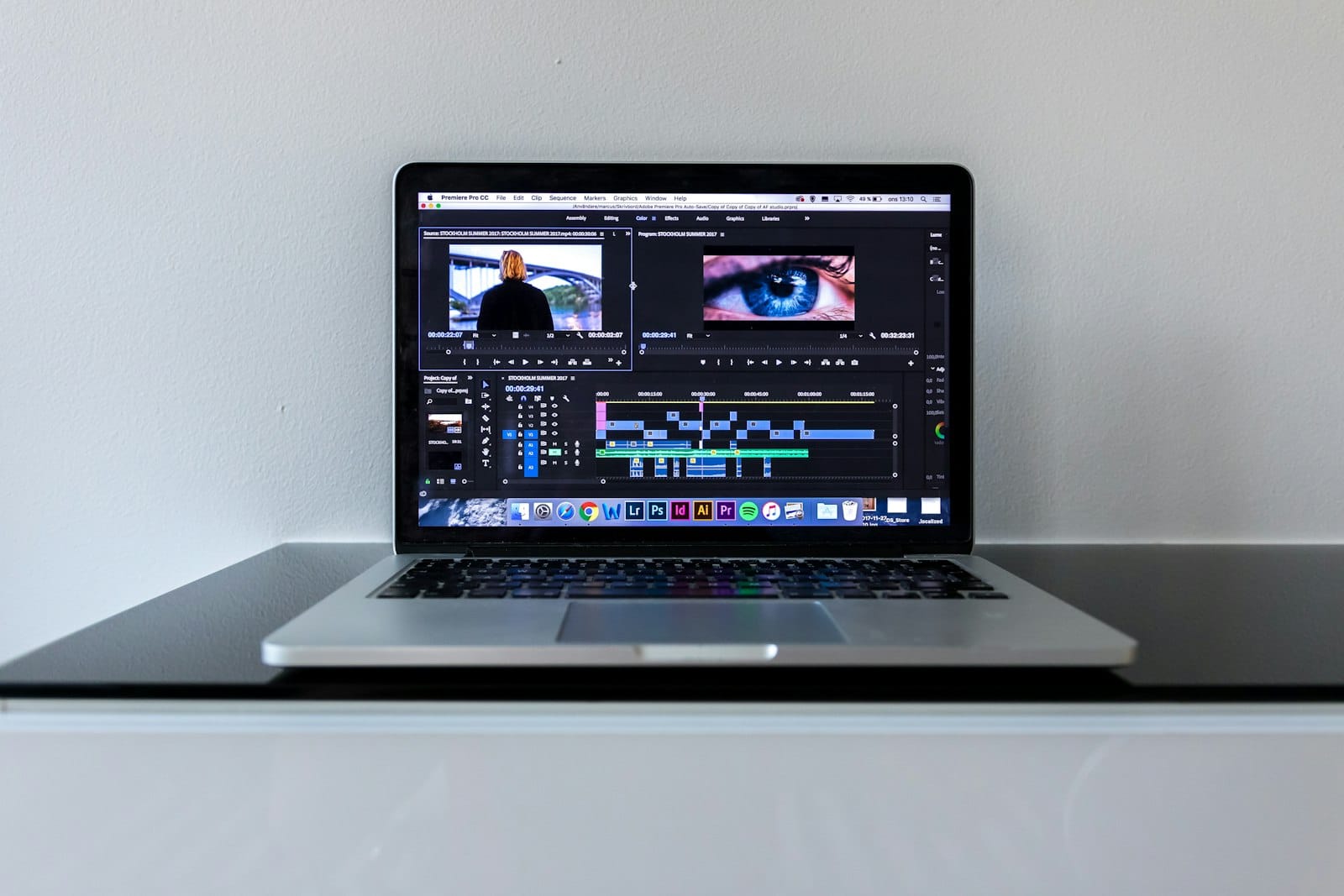 A video creator editing footage on a laptop next to a camera
