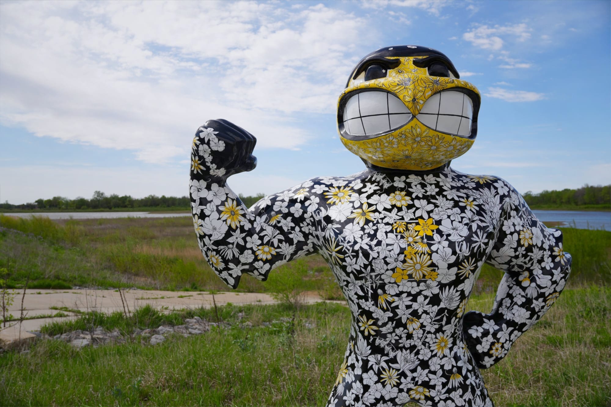 A Herky Statue with illustrations of wildflowers native to Iowa in black, white, and yellow. 