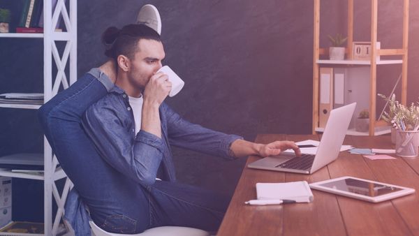 Pro Stock photo of a man sitting at a desk with his foot behind his head