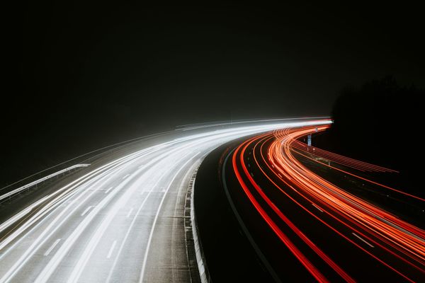 Long-exposure light trails of night highway traffic