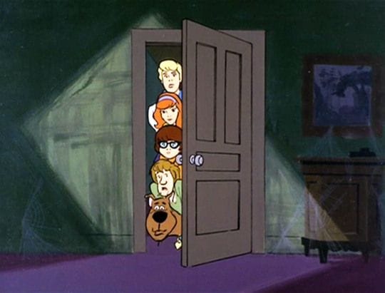 A still from Scooby Doo. The gang aligns their heads horizontally with the edge of the door