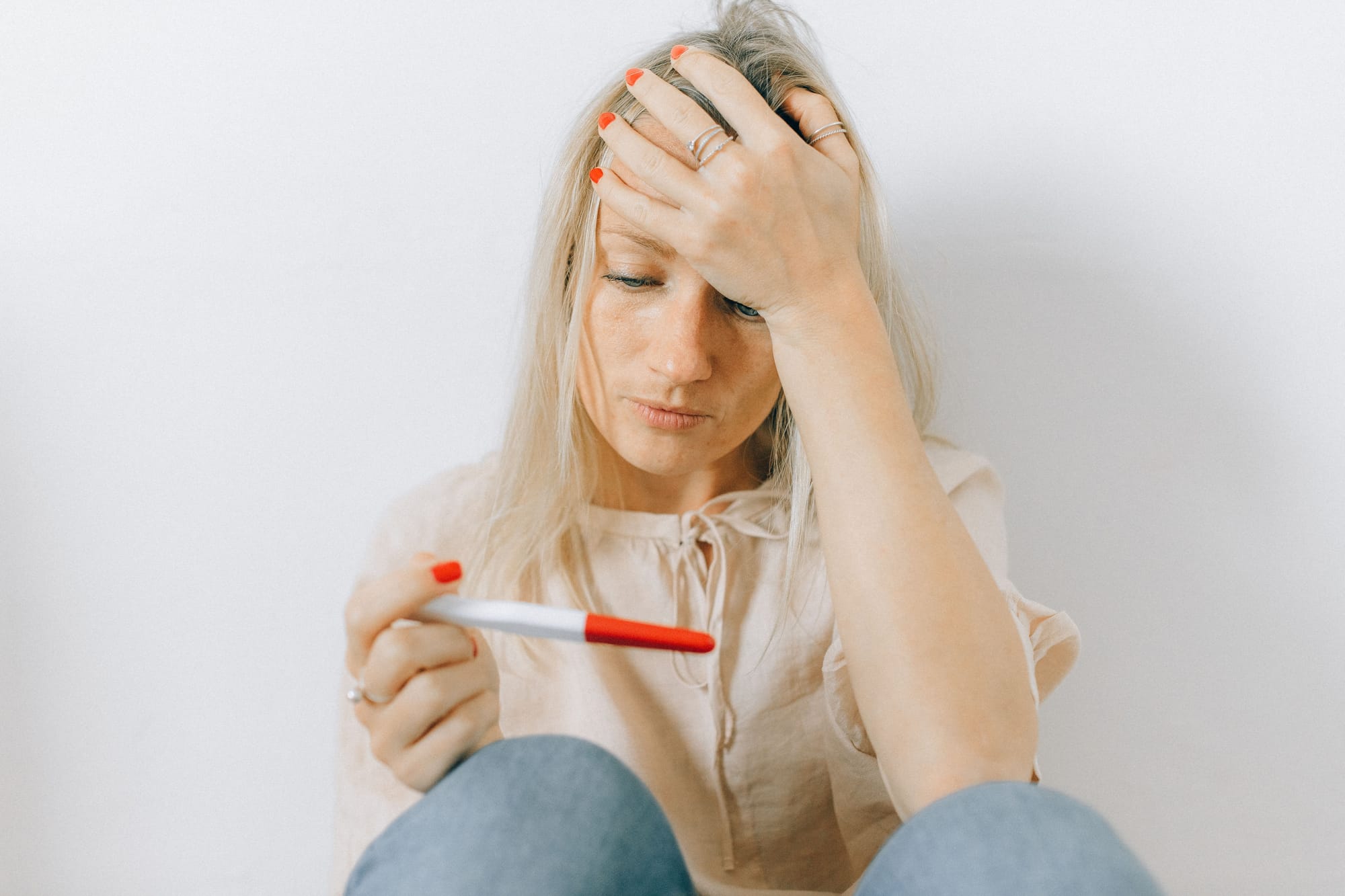 A woman holds a pregnancy test. They are concerned with the result
