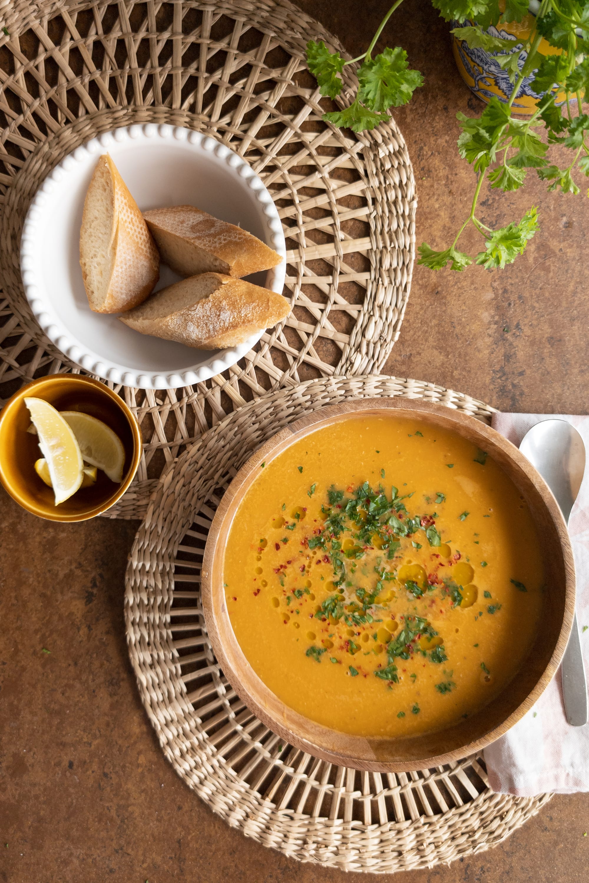 Schale mit Brot gereicht zu einem Teller Türkischer Linsensuppe, serviert mit Zitrone