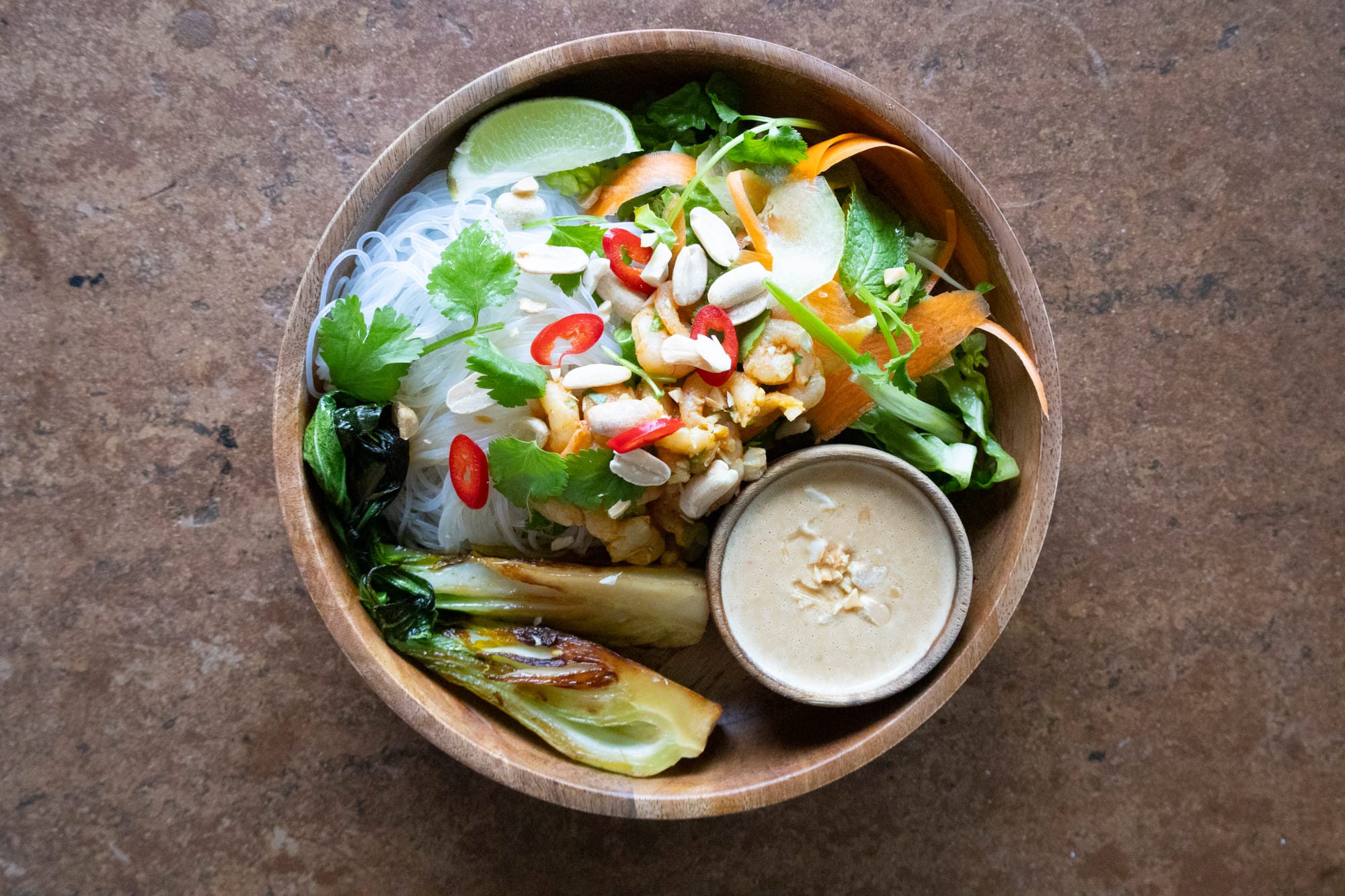 Schale mit Glasnudeln, asiatischen Salat und Erdnusssoße, garniert mit Chili und Erdnüssen
