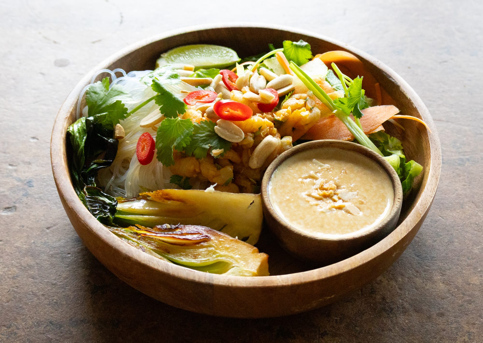 Schale mit Glasnudeln, asiatischen Salat und Erdnusssoße, garniert mit Chili und Erdnüssen