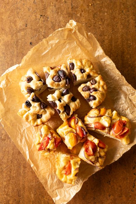 Zweierlei Focaccia: eine belegt mit Oliven, die andere mit Cherrytomaten und roten Zwiebeln. 