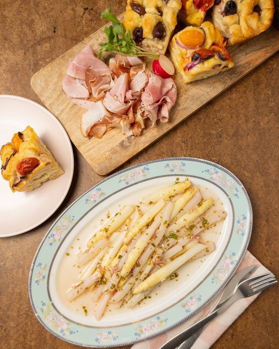 Marinierter weißer Spargel angerichtet auf einer frühlingshaften Platte.