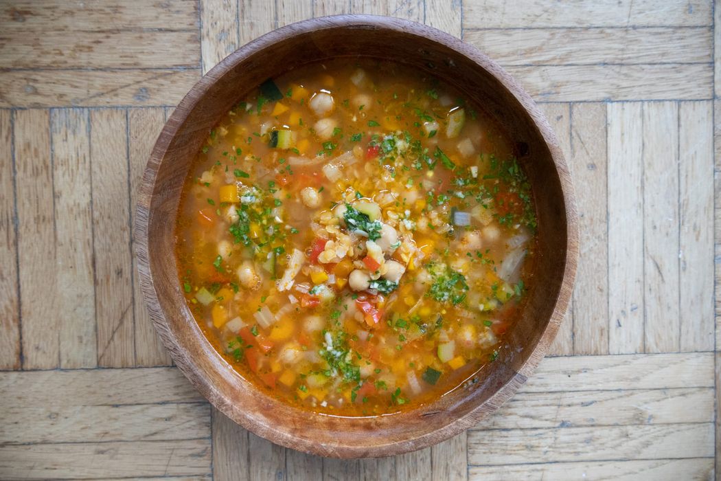 Holzschüssel mit italienischer Minestrone garniert mit Pesto