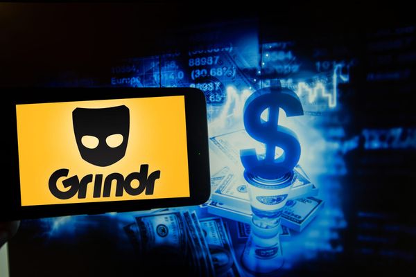 Logo of the gay dating app Grindr is seen on a screen next to an illustration of big money.