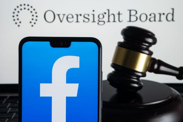 Photo illustration showing the Facebook logo on a phone next to a gavel underneath the Oversight Board logo