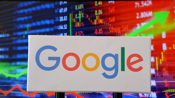 The Google logo on a white background against a screen showing stock trades