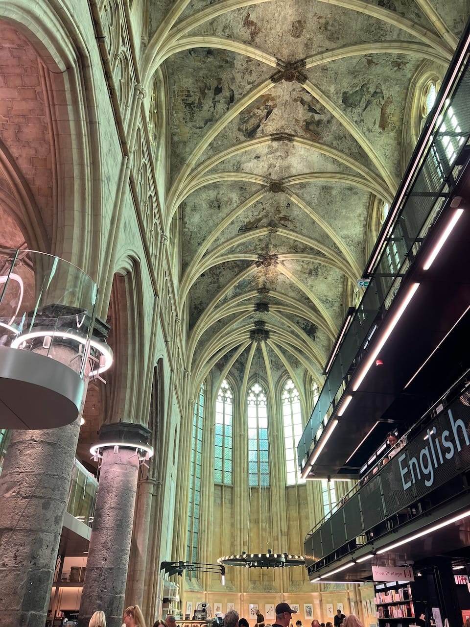 Kirche, die zu einer Buchhandlung umfunktioniert wurde. Auf dem Foto sieht man das Gewölbe, die Kirchenfenster und Säulen sowie ein Metallgerüst, was an der Seite als Etagen dient.