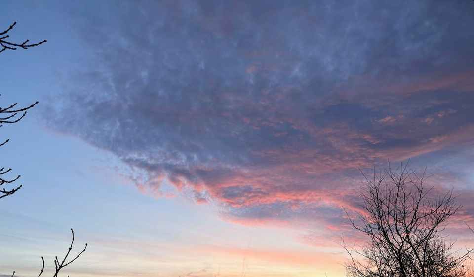die Sonne strahlt Wolken von unten rot an