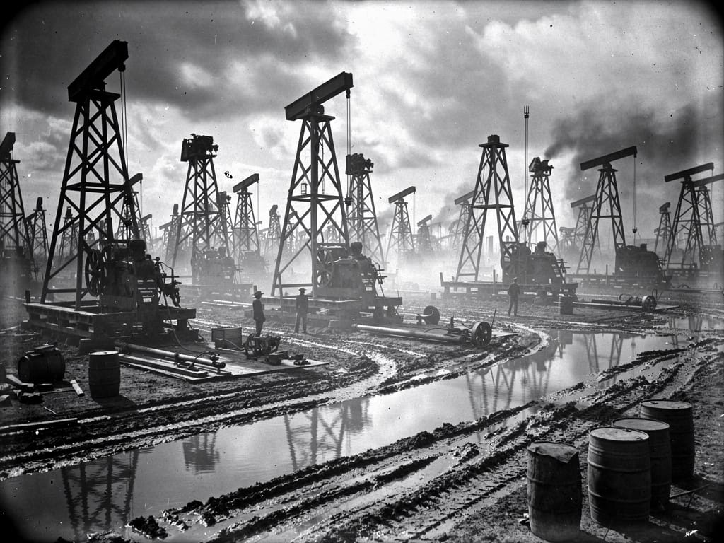 A field crowded with old wooden oil derricks from the early oil boom
