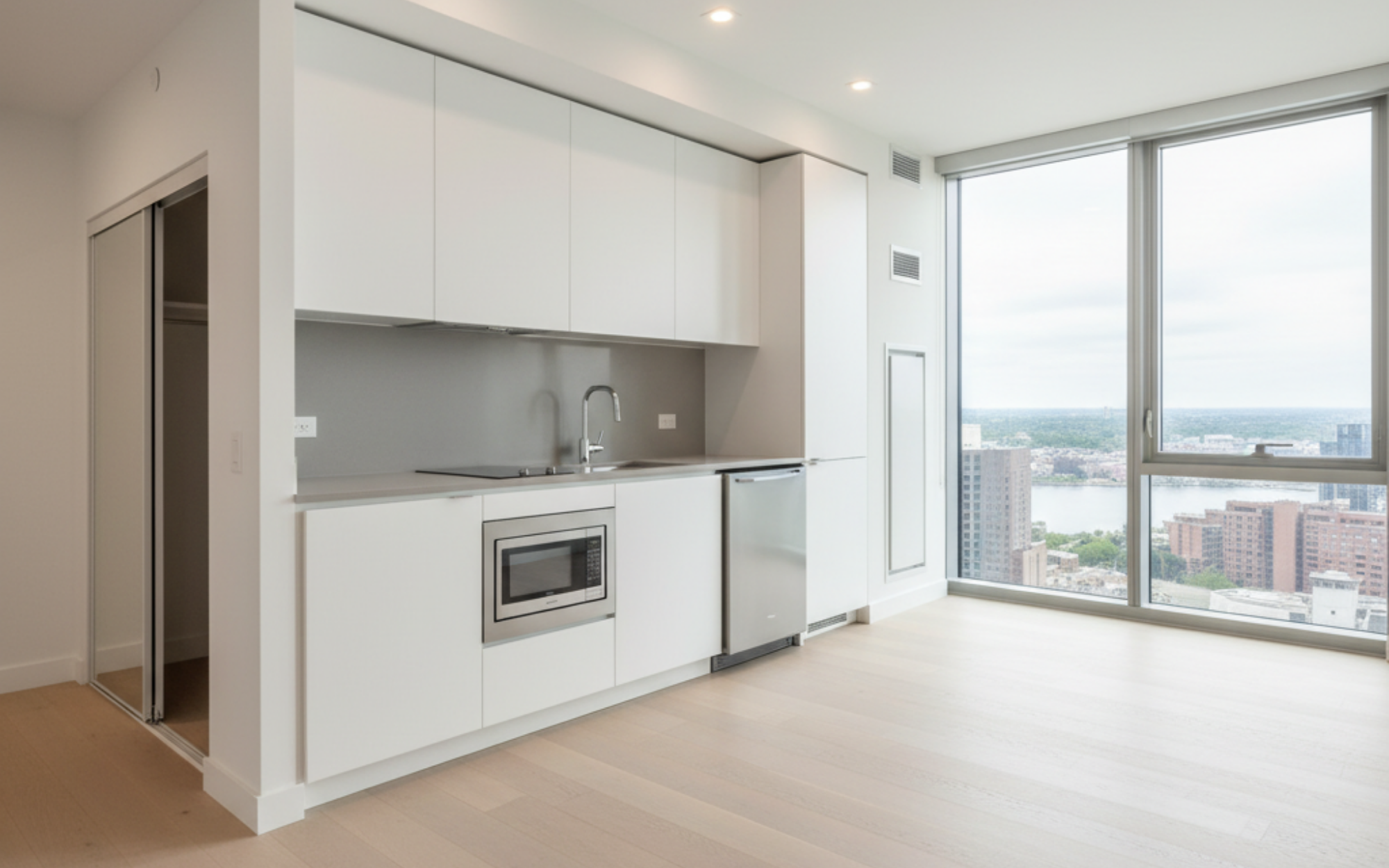 Cambridge high-rise apartment for rent featuring a modern open-concept layout with compact kitchens, efficient storage, and bright studio or one-bedroom designs. Higher floors offer stunning city views.