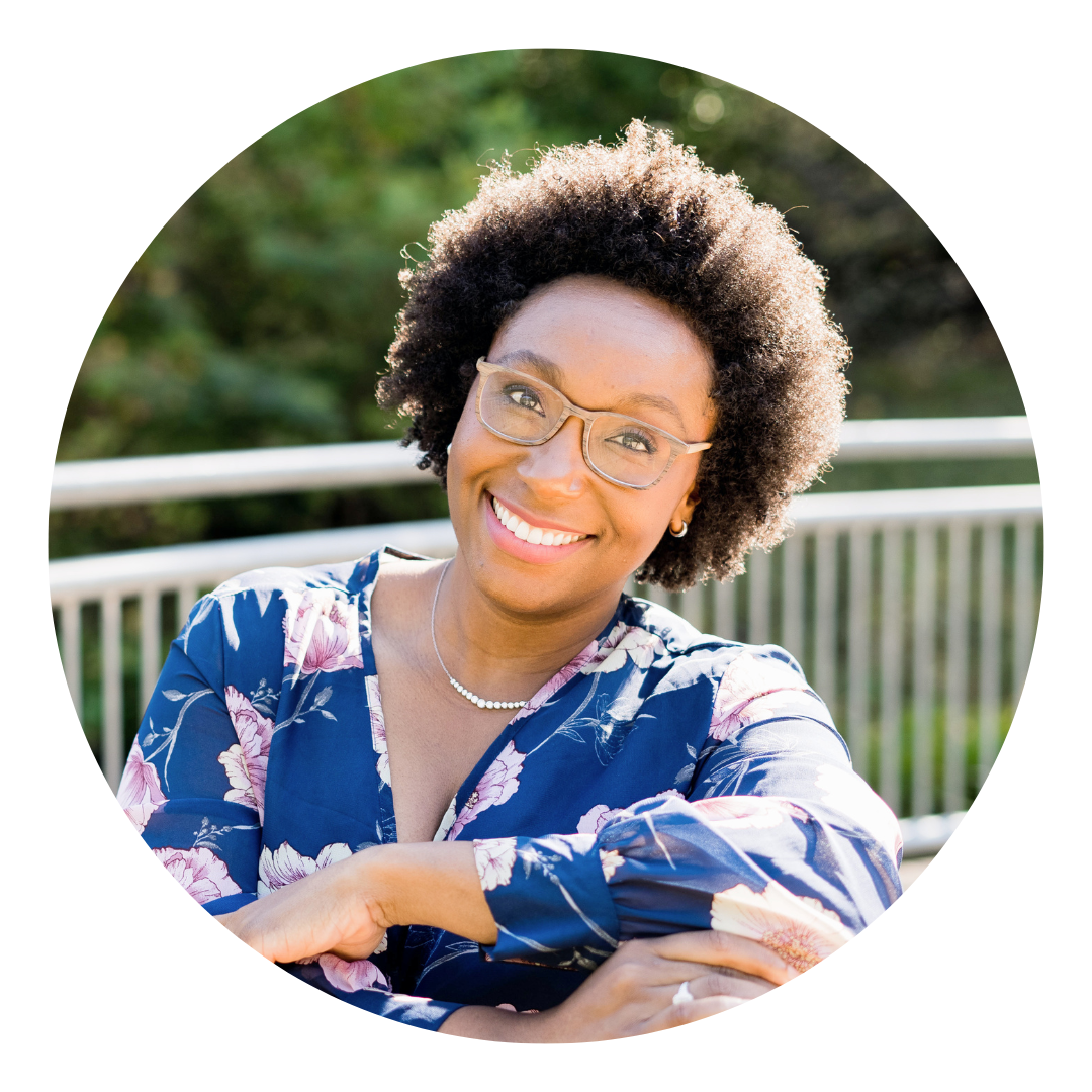 A Black woman smiles at the camera