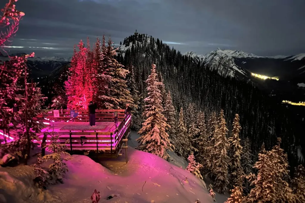 Top Of Sulphur Mountain Gondola Snowy Mountaintops In The Dark With Lit Trees At Banff Nightrise