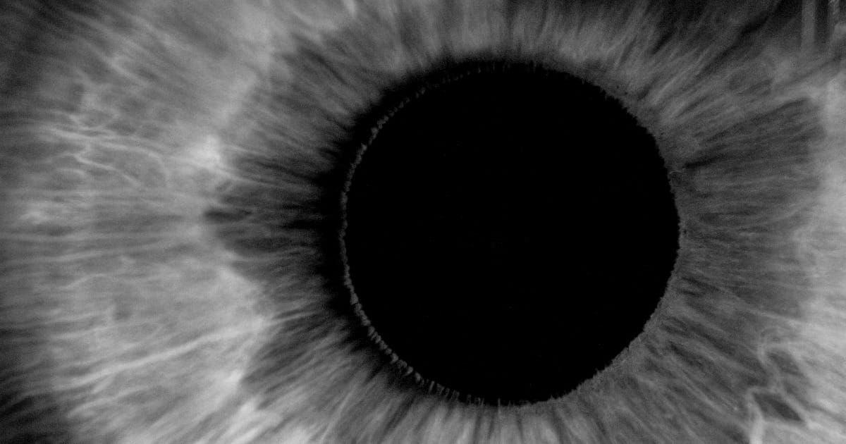 Immagine in primissimo piano dell'iride e della pupilla di un occhio umano.