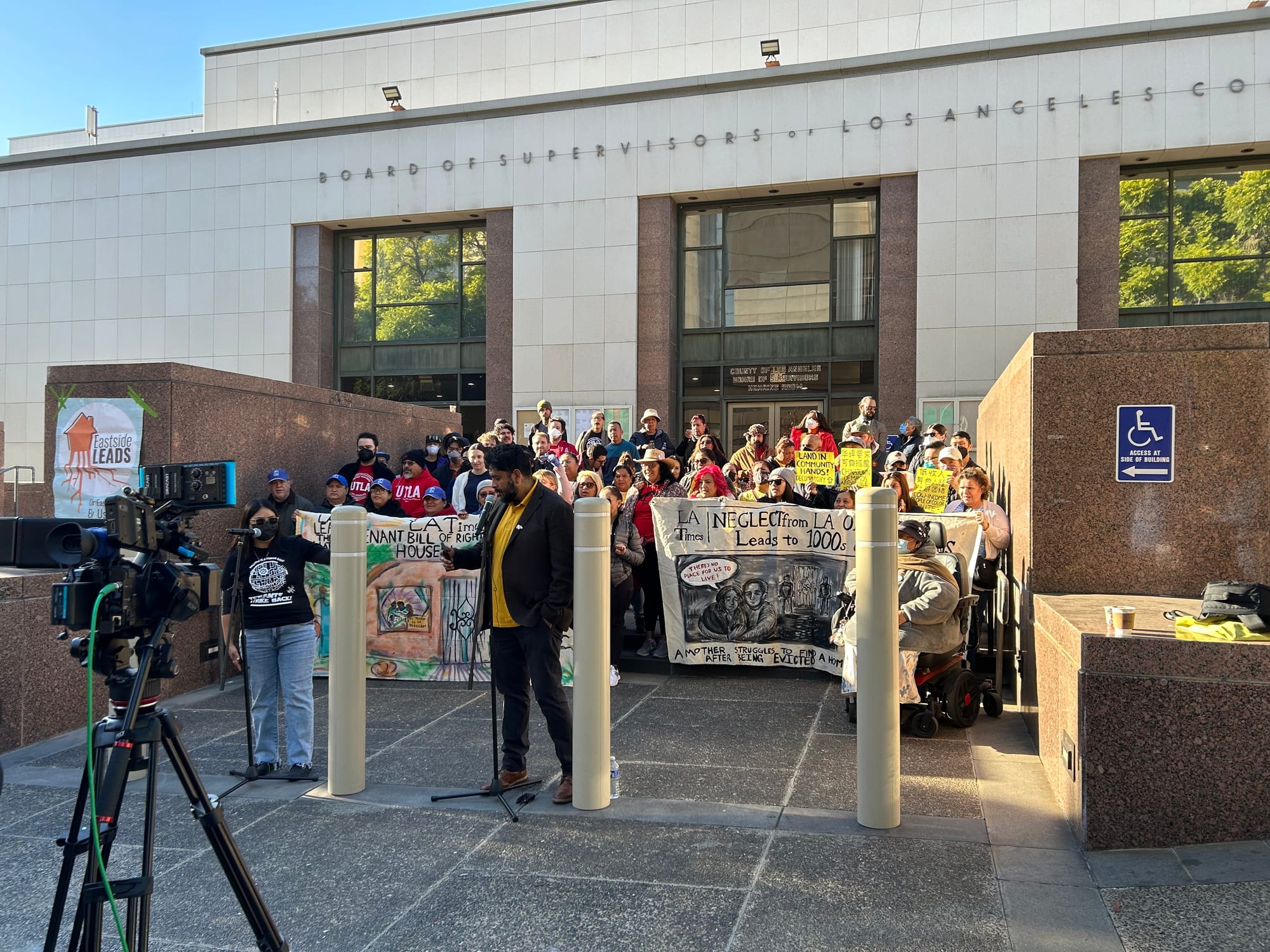A large rally of tenant organizers outside LA's county administration building holding banners about evictions and tenants rights