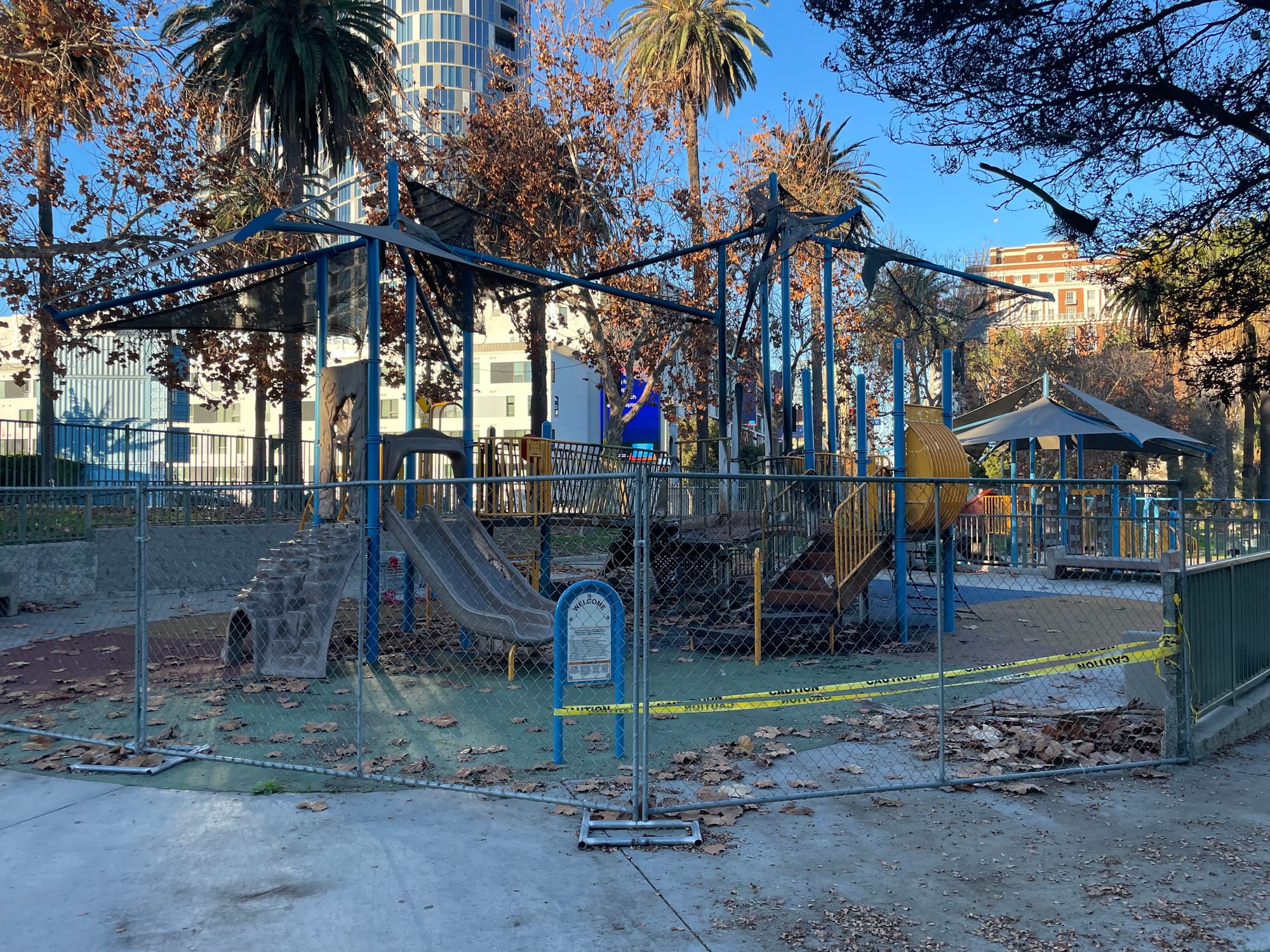 A playground in Lafayette Park that has been burned with police tape and a fence surrounding it