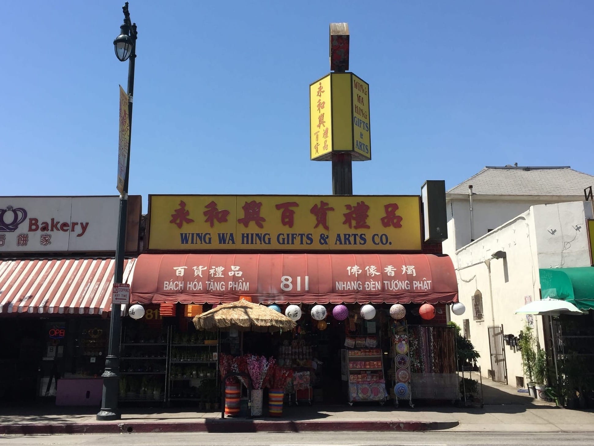 Storefronts in Chinatown show a wide range of shade tools to protect the sidewalk, including awnings and umbrellas