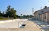 The Griffith Park Pool, a giant city pool in LA, completely empty with a red shopping cart in the middle