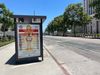 An advertisement on a bus shelter on an shadeless LA street showing "how to avoid heat stroke"