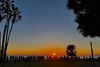 A stunning sunset over the Pacific with the silhouettes of people lined up along a fence in Santa Monica to watch it