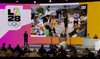 A presentation being made by Reynold Hoover onstage at the IOC summit with a giant LA28 logo
