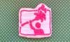 A cookie in the shape of the Torched logo, with a hot pink icon of a person holding a burning palm tree