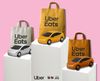 An Olympic podium showing Uber Eats bags as "medals" with corresponding cars and the Uber and LA28 logos