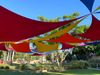 A colorful shade canopy over a grassy Grand Park lawn helps to shade areas not covered by trees