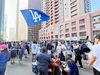 Dodger fans partying on Grand's downtown streets holding flags, buying hats, and eating hot dogs
