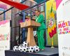 Mayor Karen Bass is in a soccer-pitch green suit standing at a city of LA podium with soccer balls and Casa Mexico banners