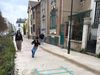 A young child runs along colorful graphics on a Paris street that's been painted and added plantings and trees